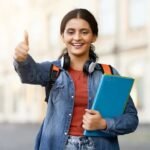 indian-student-giving-thumbs-up-campus-lady-books-gives-portraying-approval-positivity-educational-environment-314905008